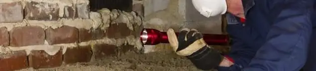 Pest control technician inspecting a crawl space for ant activity and entry points in Hialeah, FL