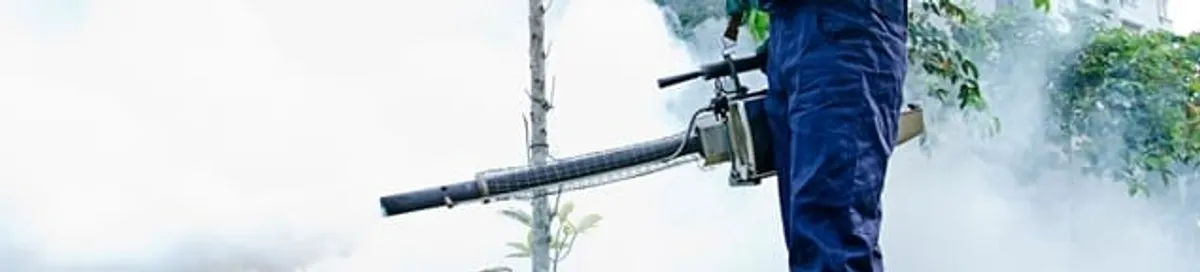 Pest control technician fogging an outdoor area for insect control in Hialeah, FL