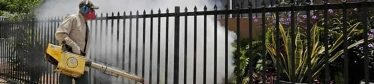 Mosquito control technician fogging a yard perimeter for mosquito reduction in Hialeah, FL